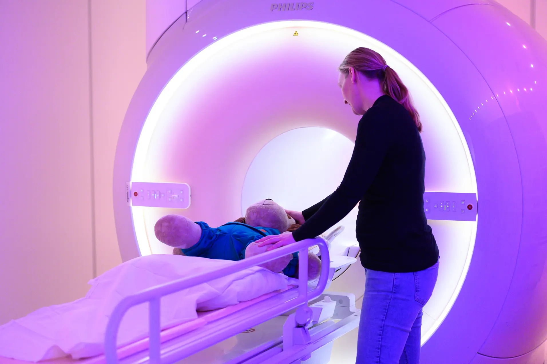 En kvinne som står ved siden av en baby i en sykehusseng