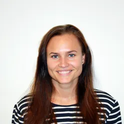 Kvinne smiler til kameraet
