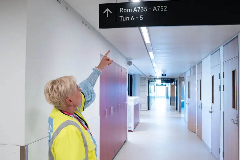 En gutt som peker på et skilt