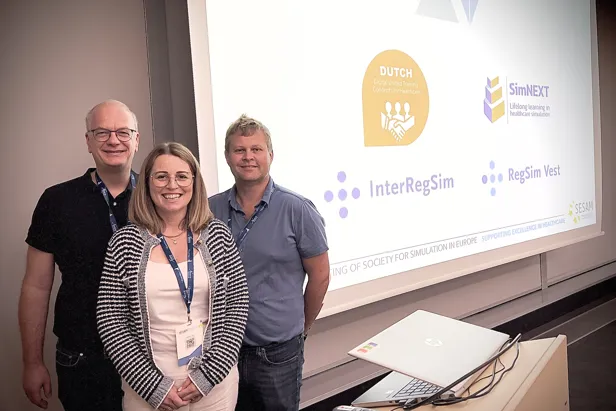 Noen få personer som står foran en projektorskjerm