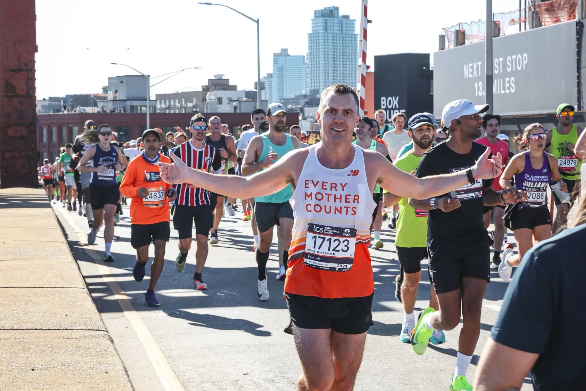 En gruppe mennesker som løper på en vei under en bro