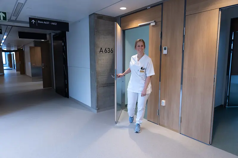 En sykepleier som står i en gang