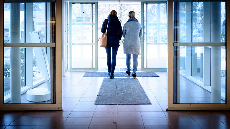 Et par kvinner som går gjennom en bygning