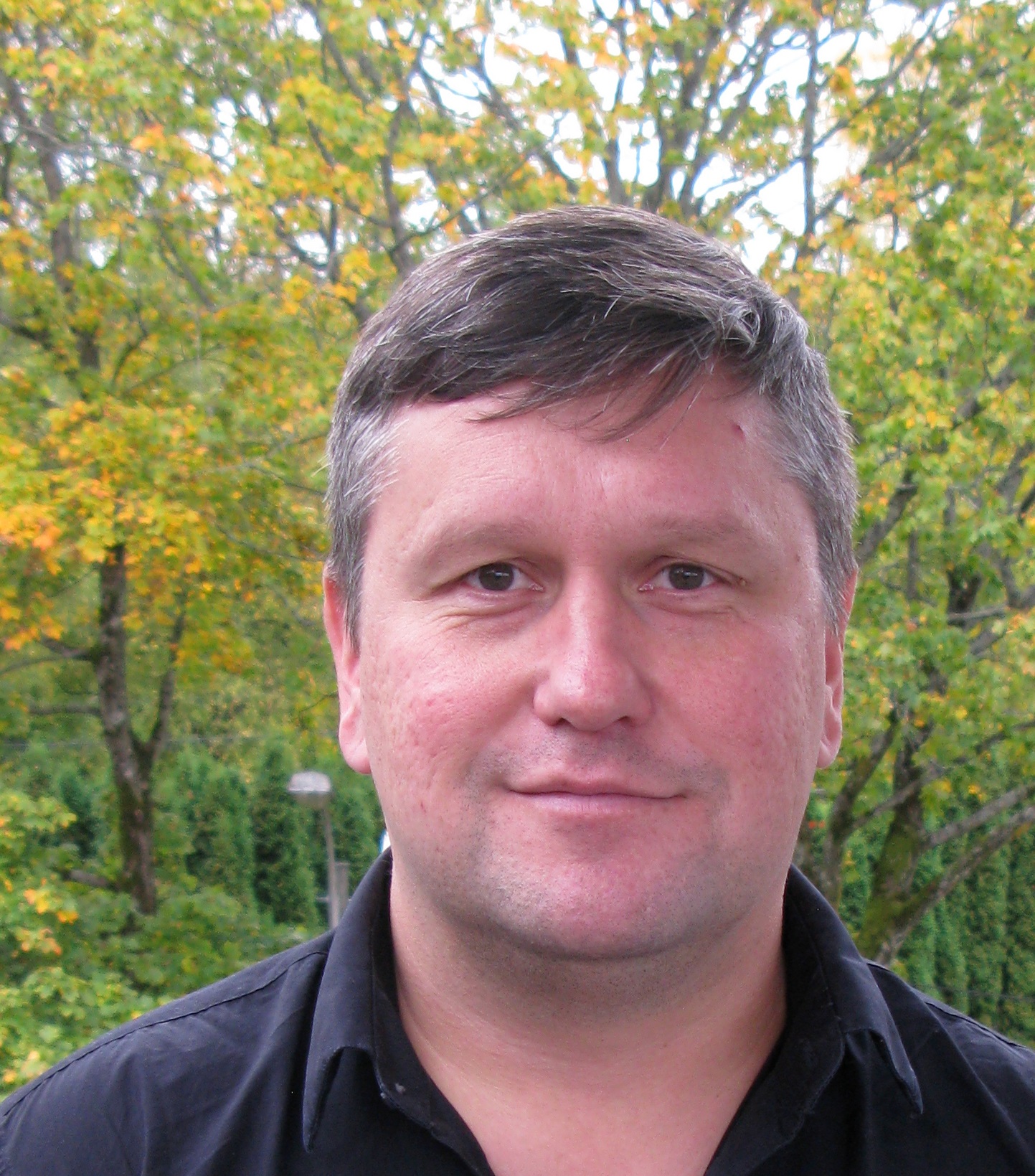 En mann som står foran trær