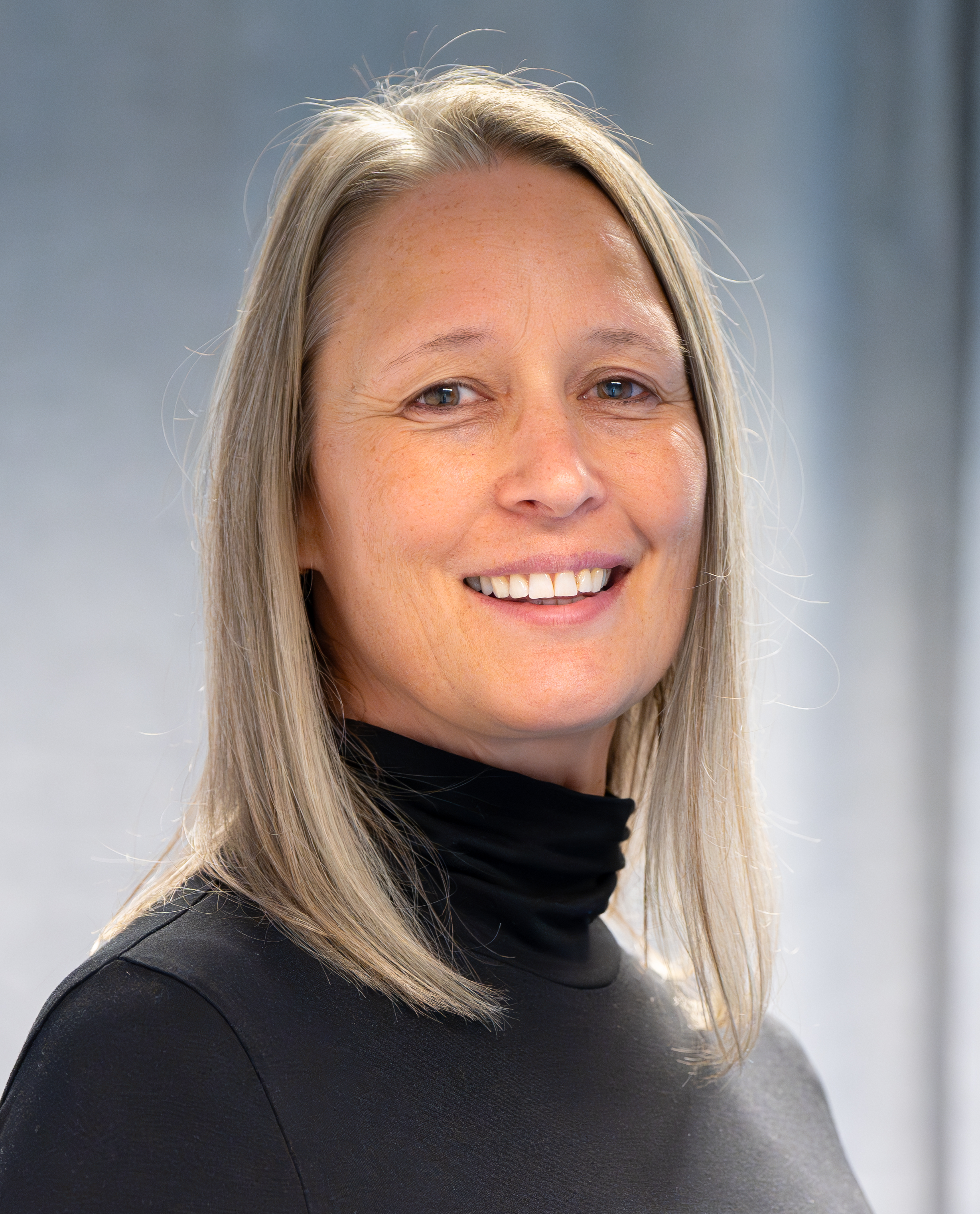 Kvinne smiler til kameraet