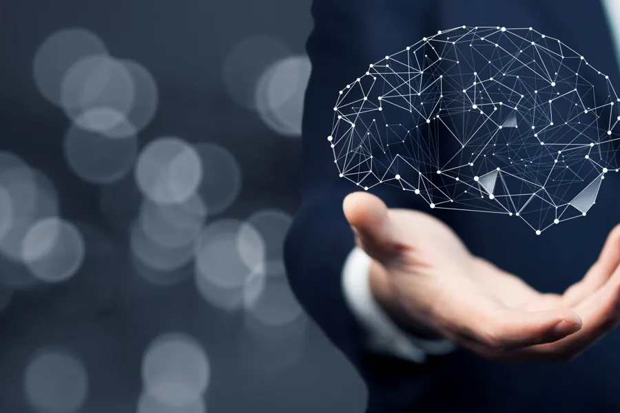 Over hånden er det illustrert en menneskehjerne.