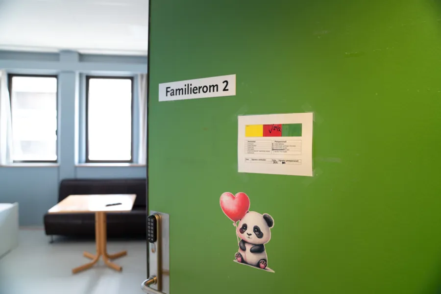 En grønn vegg med et skilt på