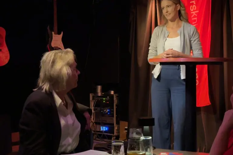 En person som står foran et podium med en person som sitter på podiet