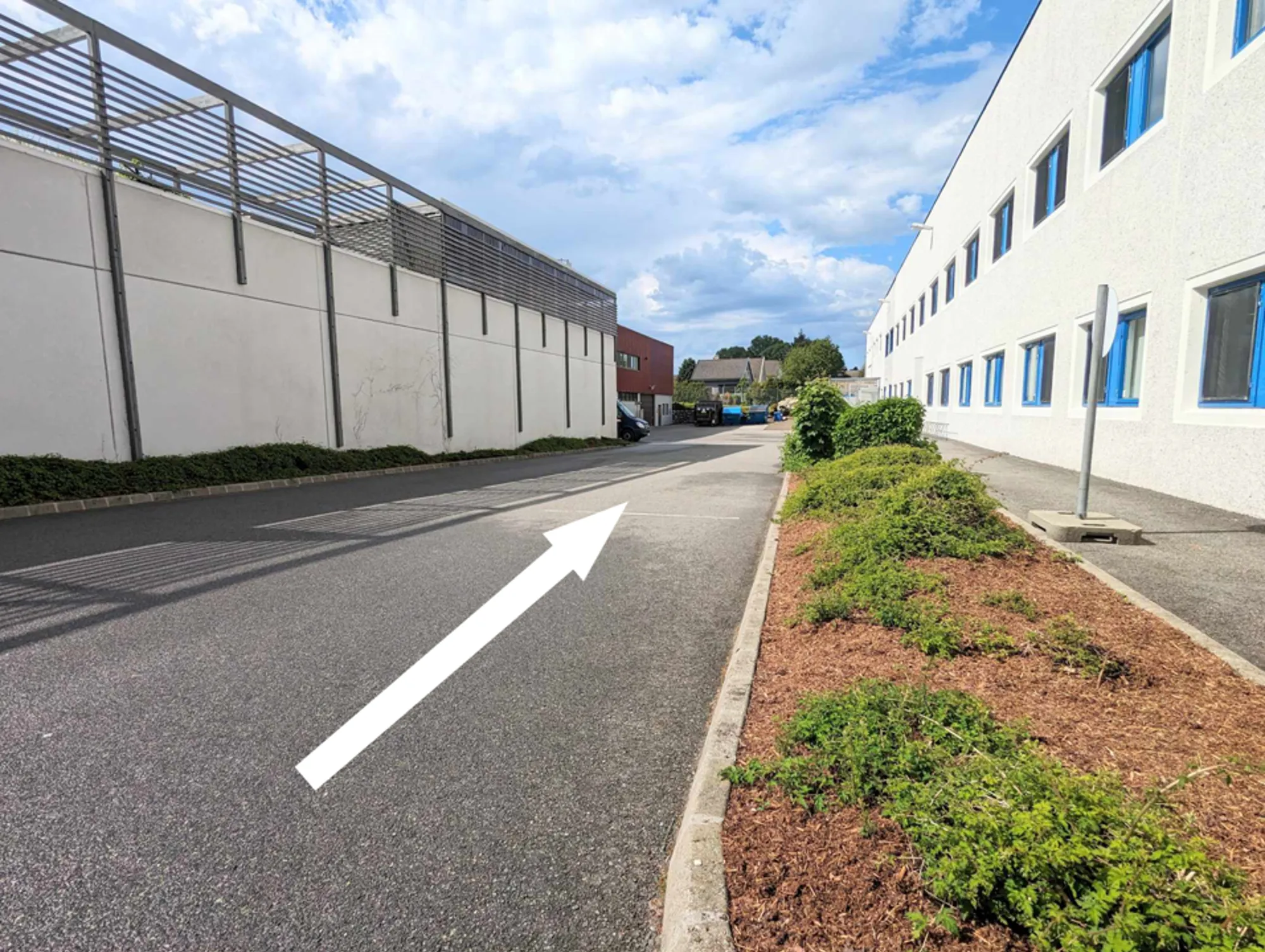 Bilde av parkeringsplass mellom to bygg.