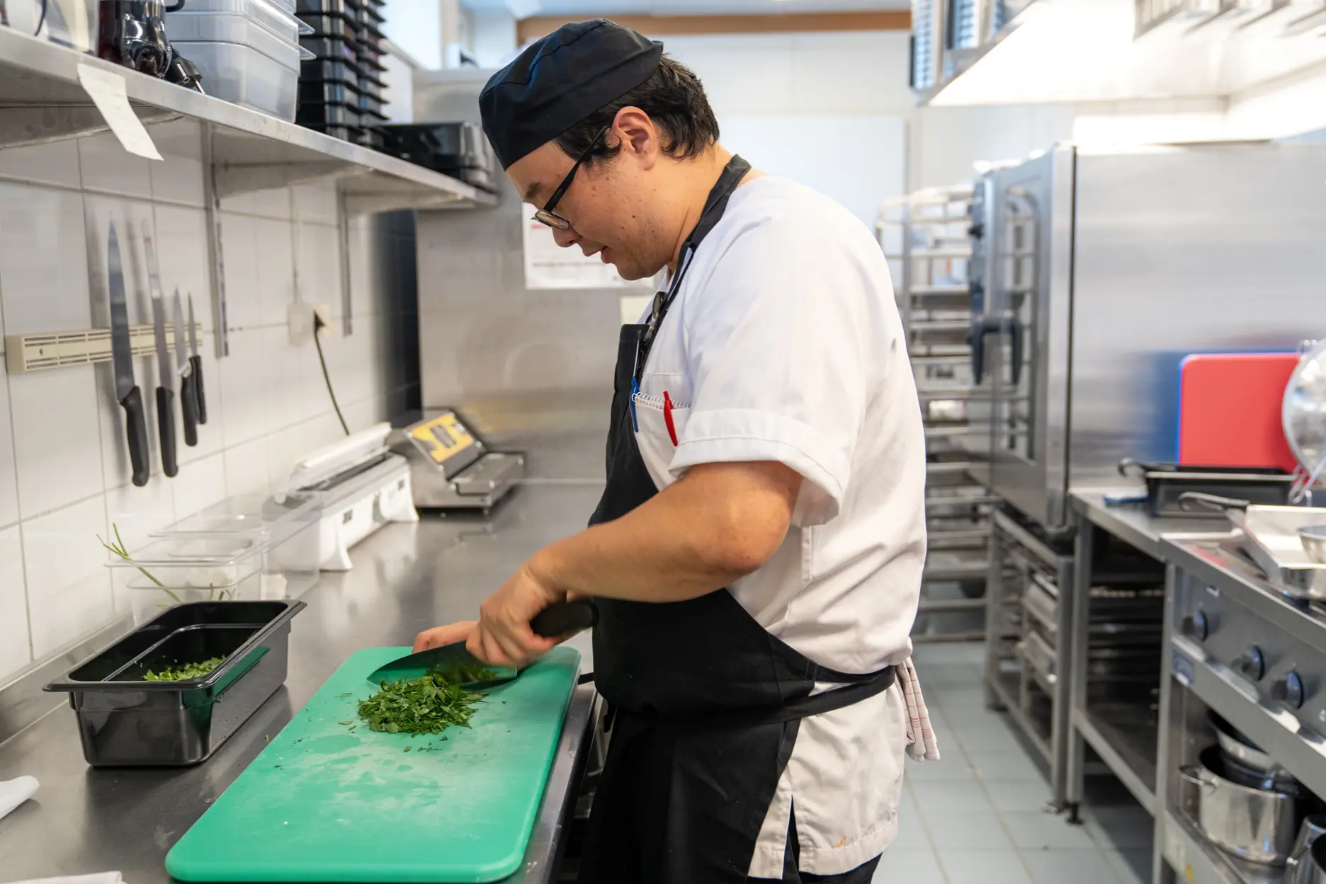 Mannlig kokk kutter opp urter