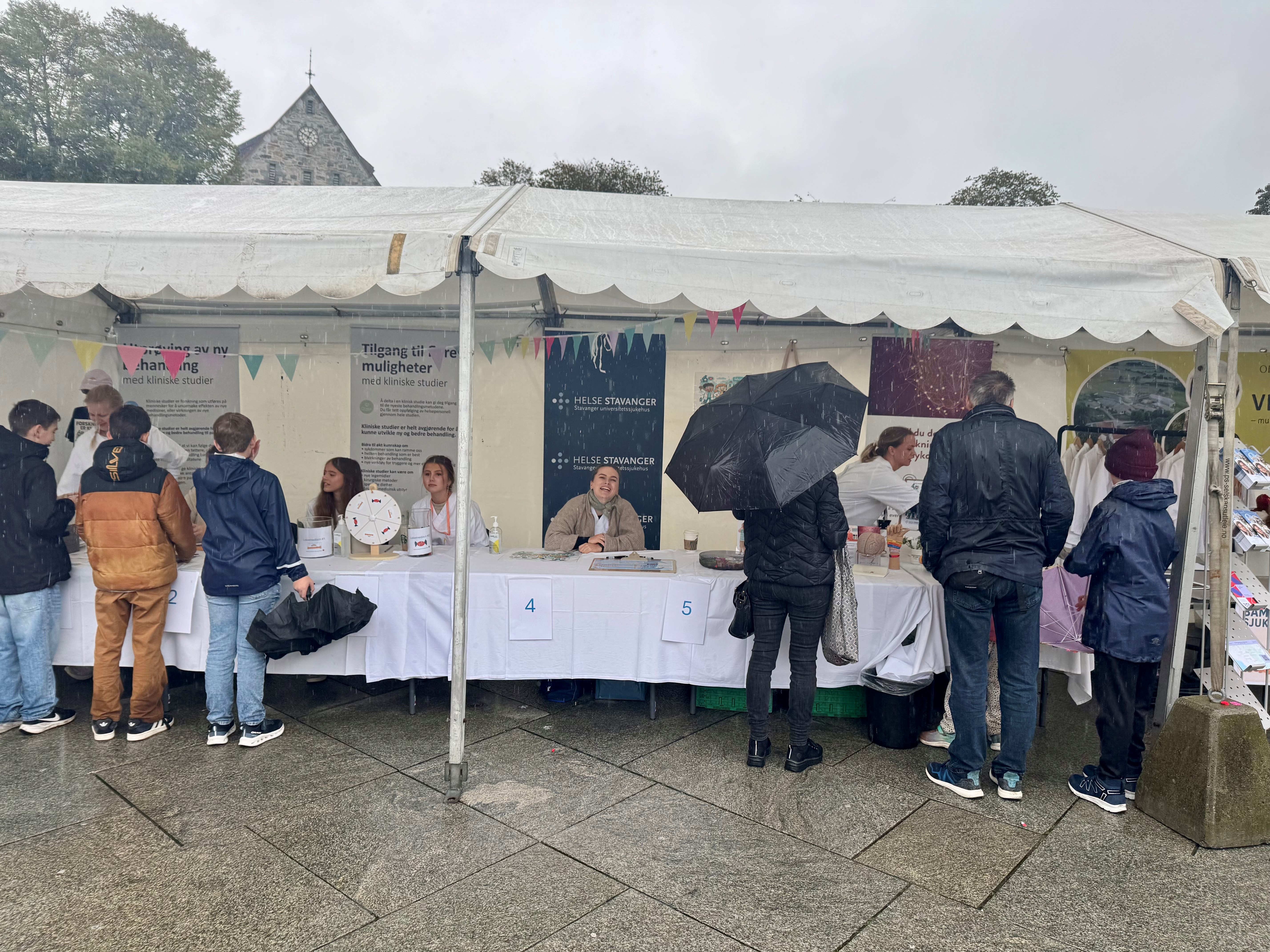 Personer som står foran en stand