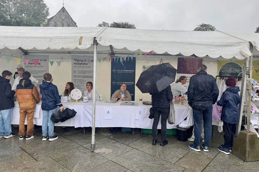 Personer som står foran en stand