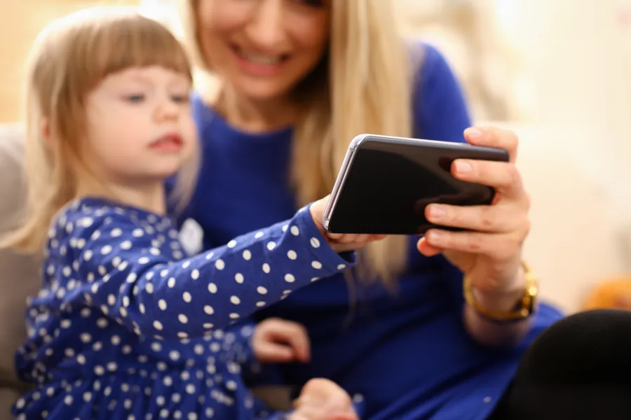 En kvinne og et barn som ser på et nettbrett