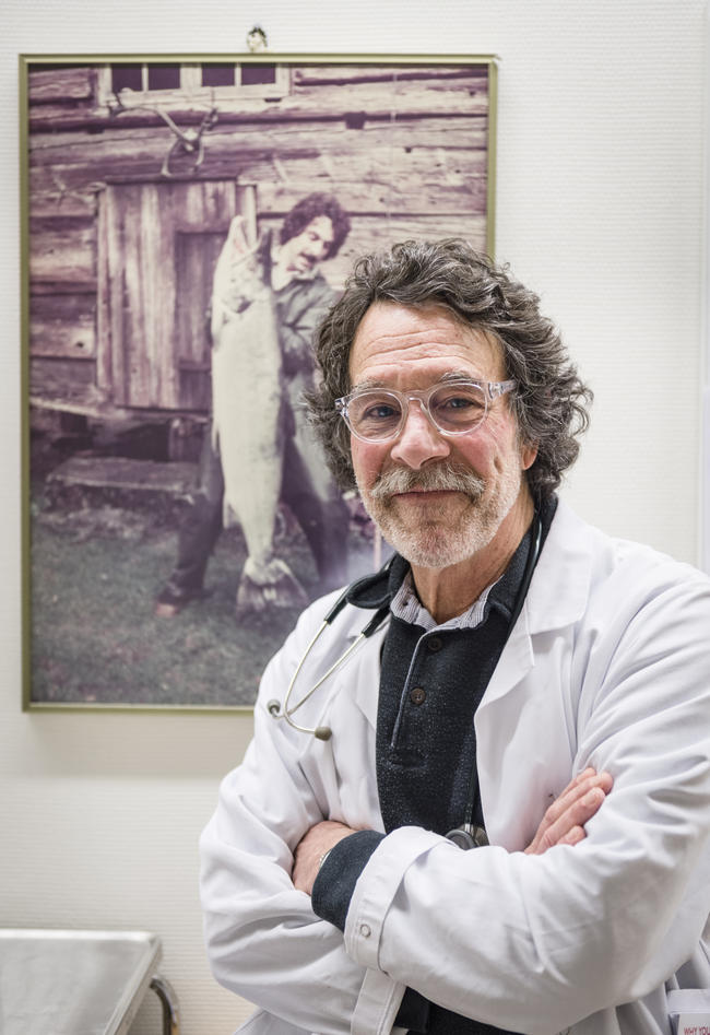 A man with glasses smiling