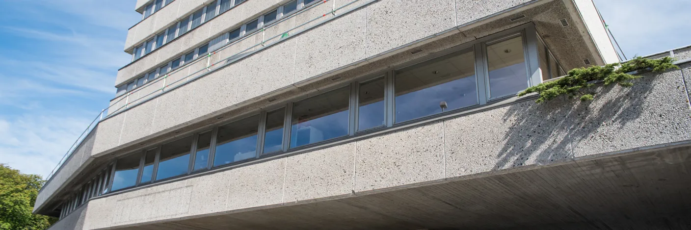 Gråtthvitt og høyt murbygg.