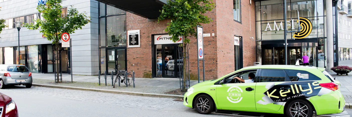 Rødt murbygg med glassgang over veien utenfor. Kjøpesenter Amfi i samme bygget.