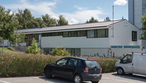 Hvit trebygning ved siden av internatet. Inngang på den ene langsiden av bygningen.