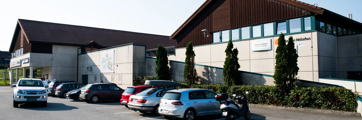 Brunt trebygg med grå mur.