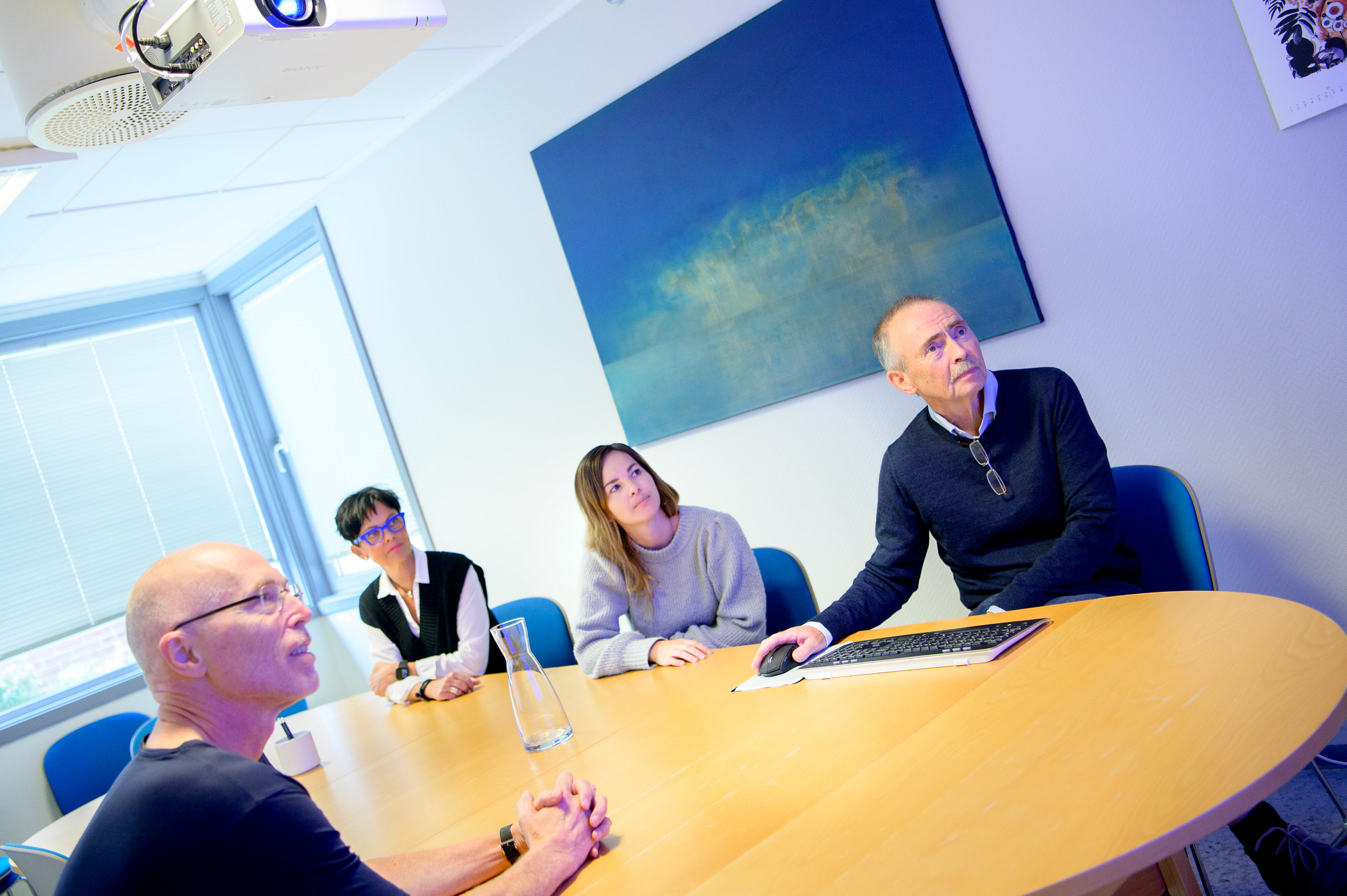 To kvinner og to menn rundt et bord