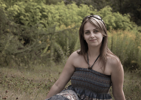 En ung kvinne ser inn i kameraet. Foto.