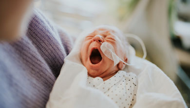 Nyfødt baby som gjesper. Bilde.