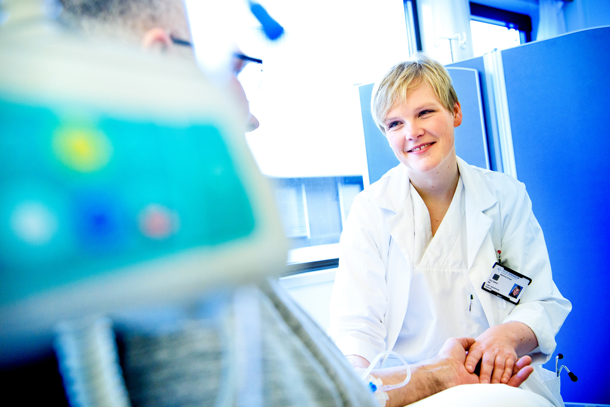 Lege som holder pasient i hånden. Foto.