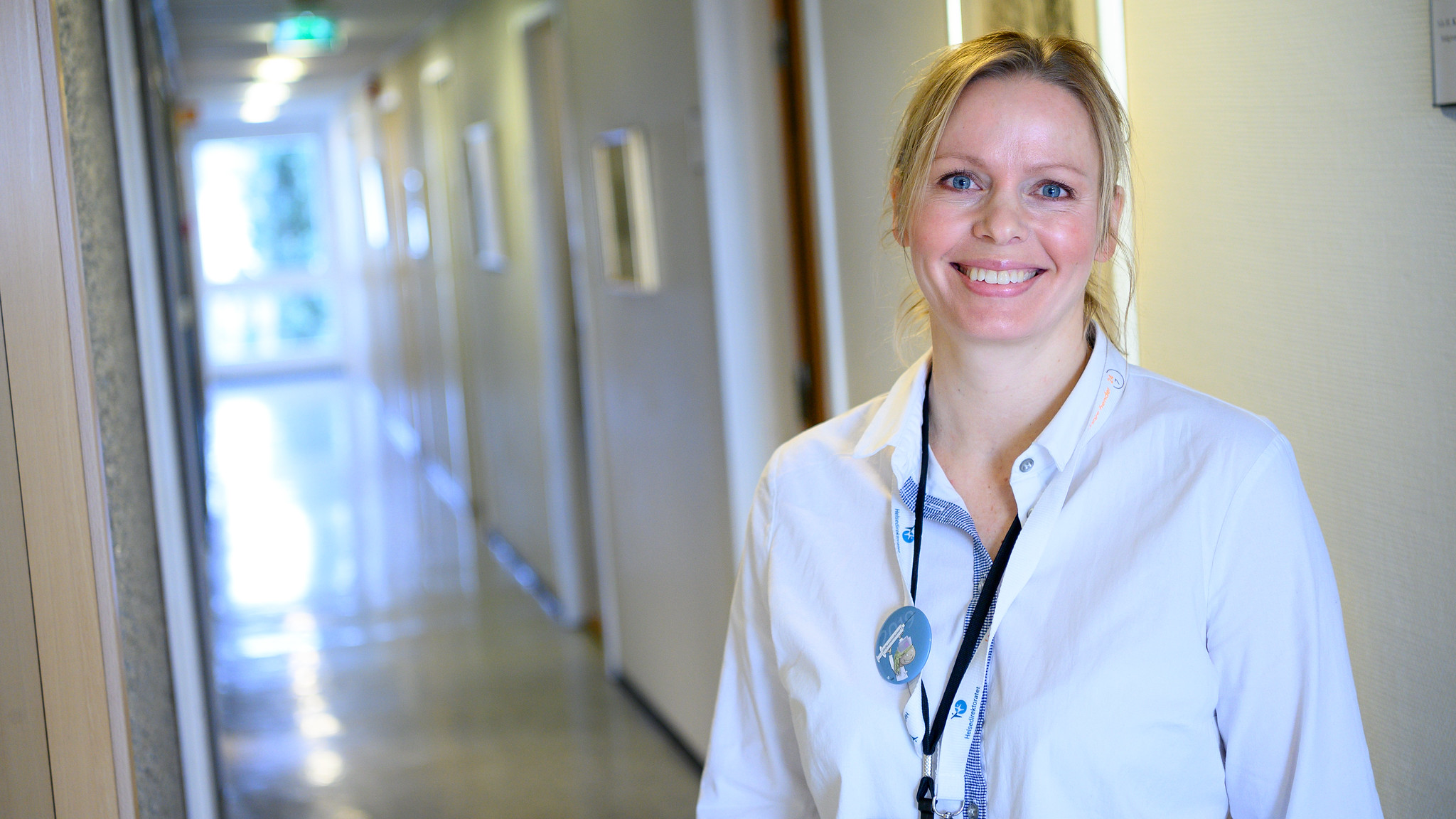 Rådgiver på kvalitet og pasientsikkerhet smiler i en gang. Foto