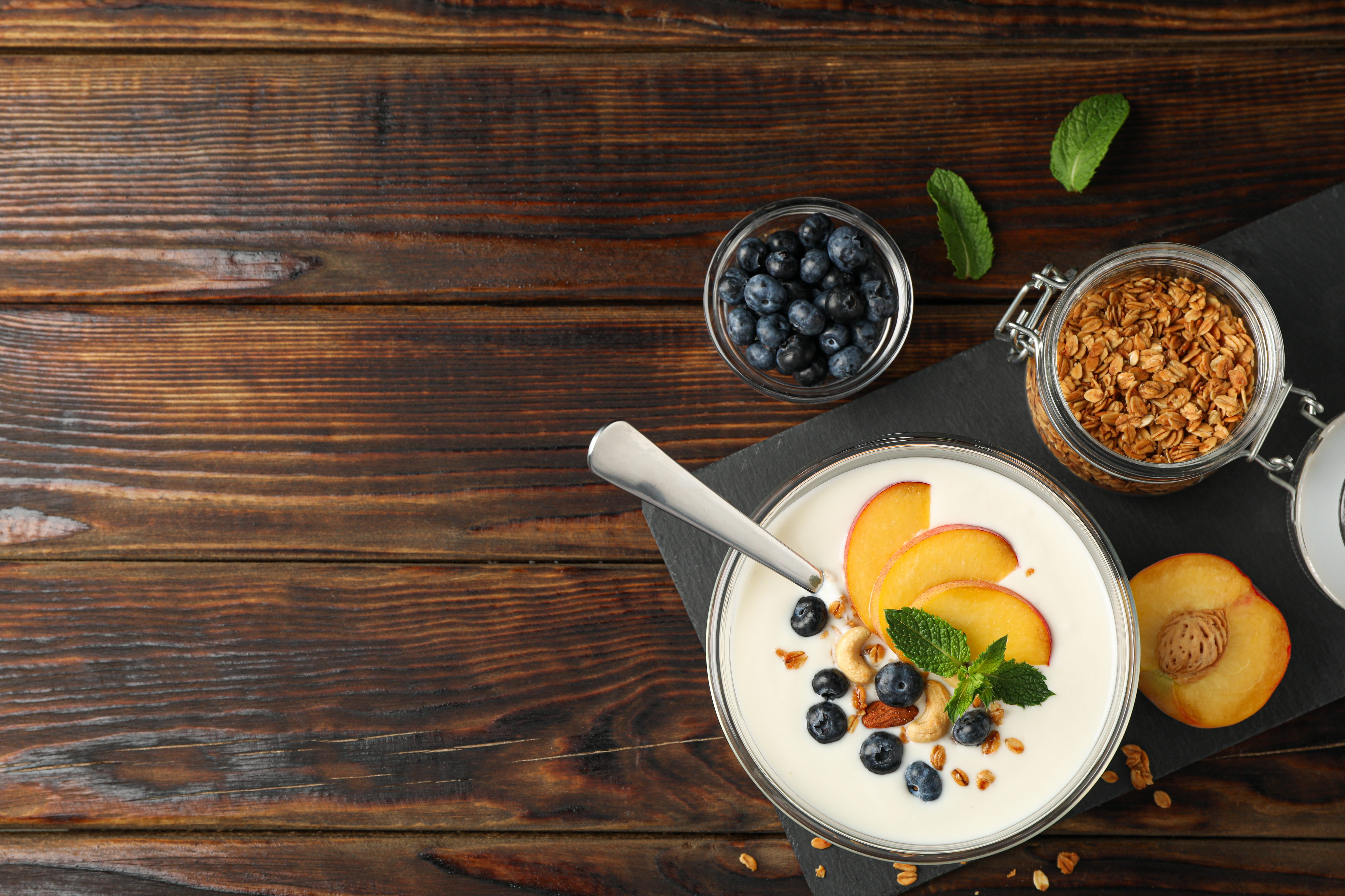Yoghurt og gryn og frukt på et bord. Bilde.