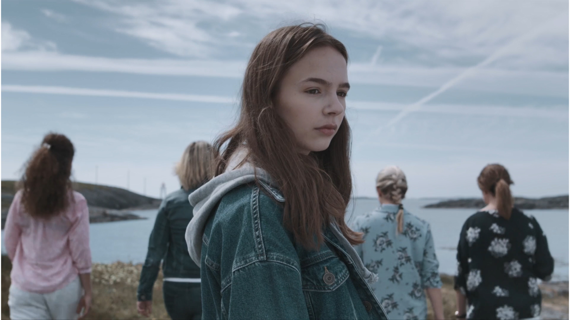 4 personer i bakgrunnen, jente i forgrunnen