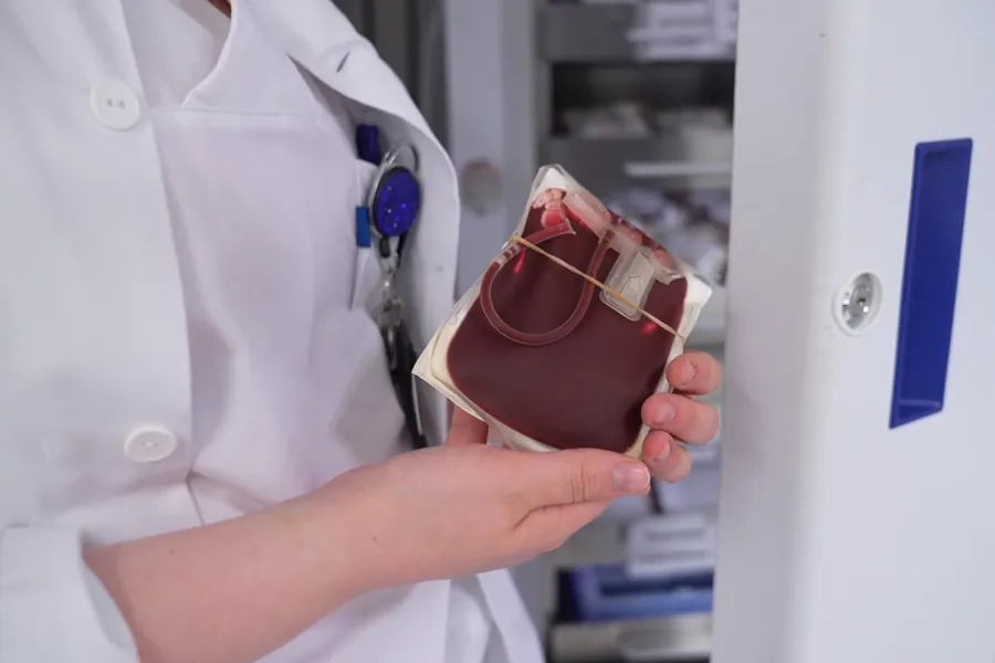 En lege som holder et stetoskop over hodet til en pasient