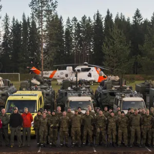 En gruppe mennesker som står foran et helikopter