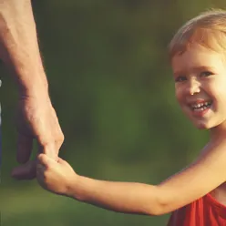 Jente som holder far i hånden og smiler. Foto.