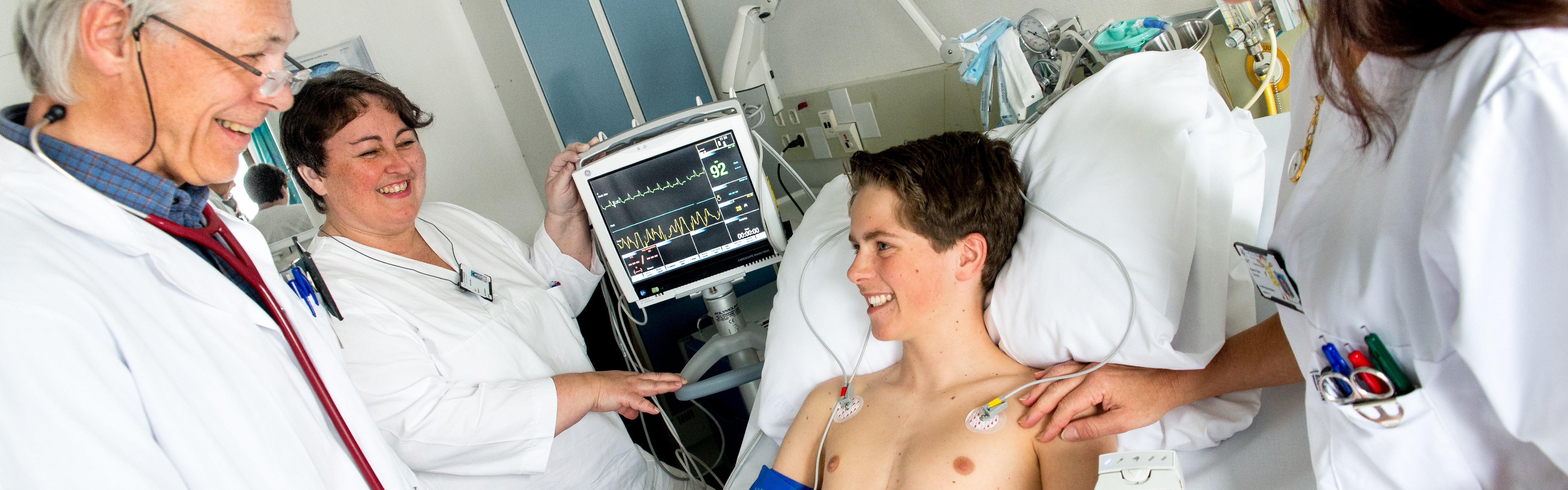 Lege som besøker et barn ved sengen. Foto.