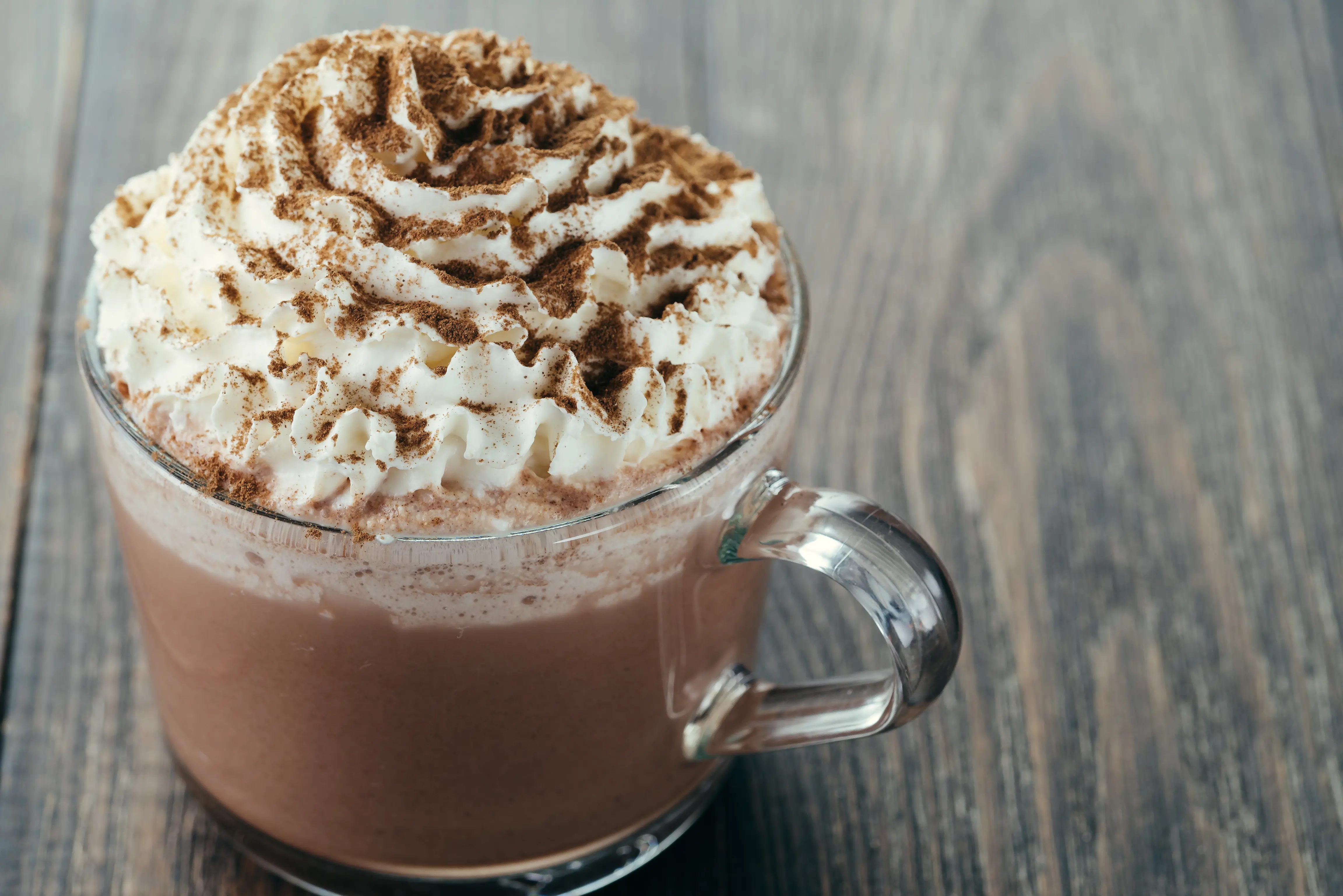Varm kakao med krem i et glass. Foto.