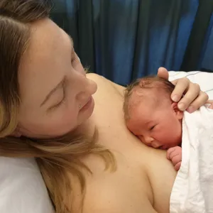 Mor med barn på brystet. Foto.