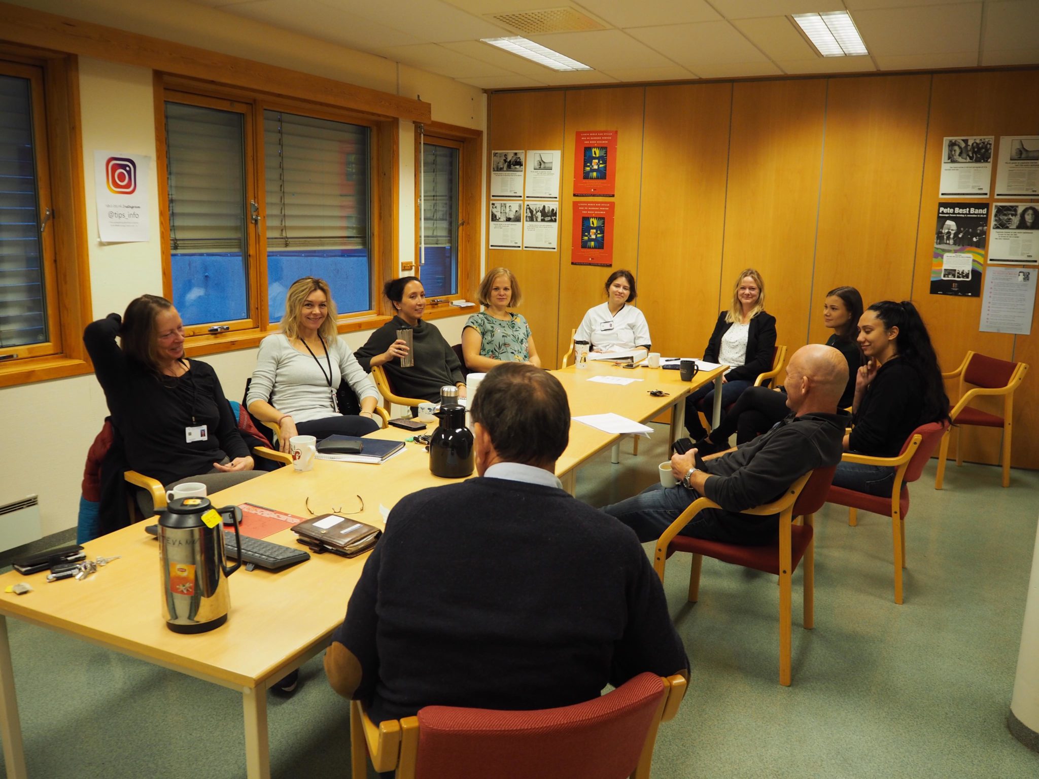 Mennesker sitter rundt et bord i et møte