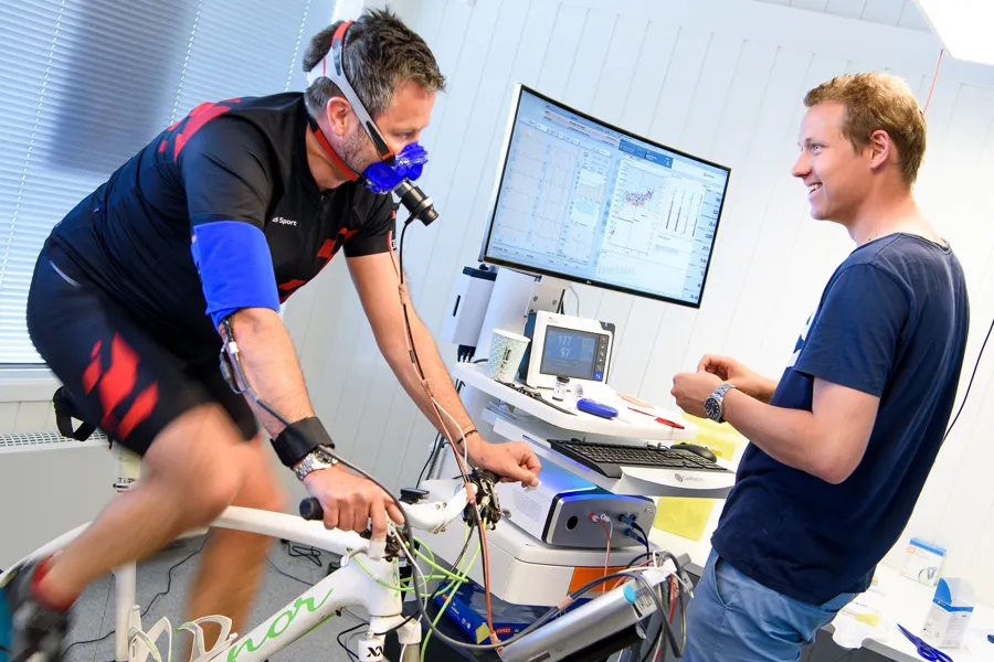 En mann som sykler og snakker med forsker.