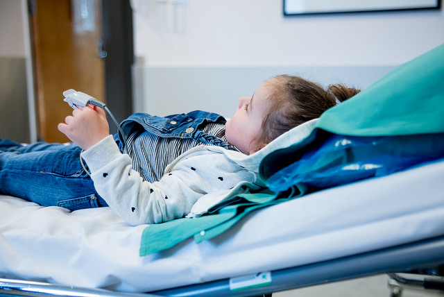 Barn som lilgger på sykehusseng. Foto.