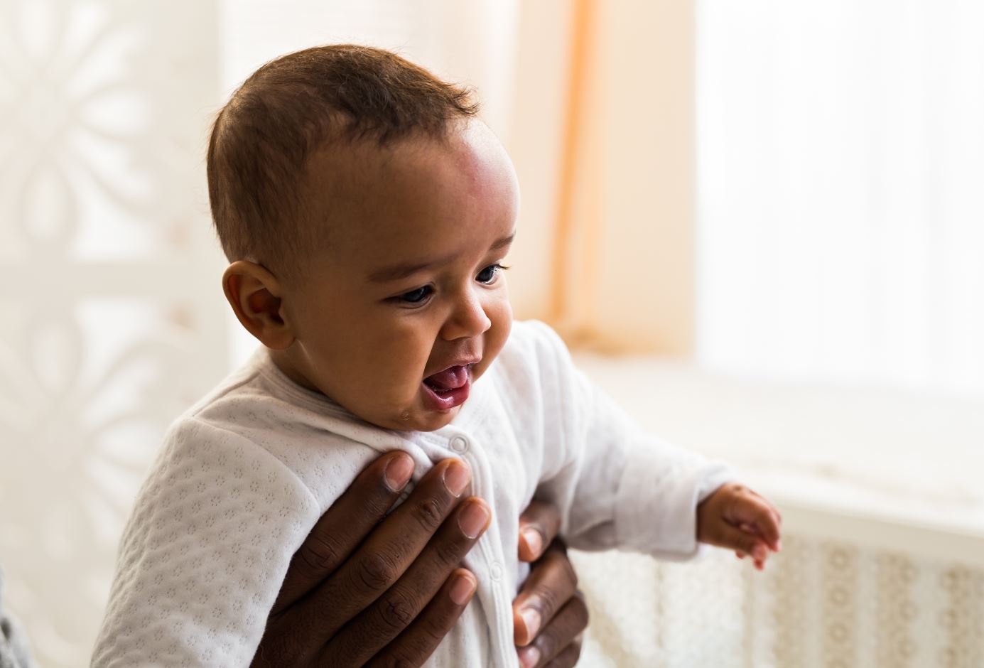Et lite barn holdes opp av en voksen