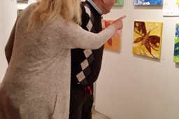 Anita og en mann ser på bilder i galleriet. Foto.