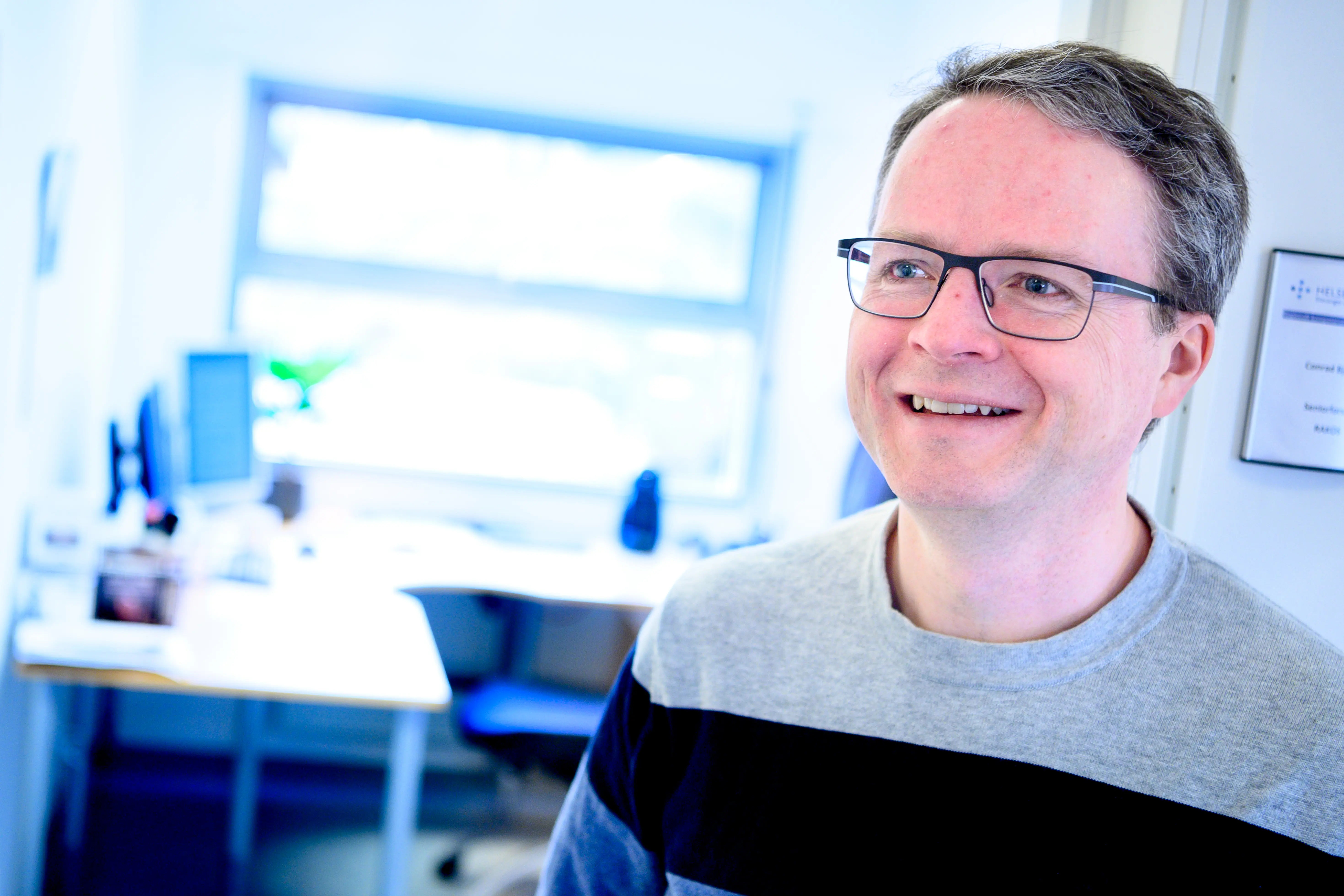 Mann med briller som smiler.