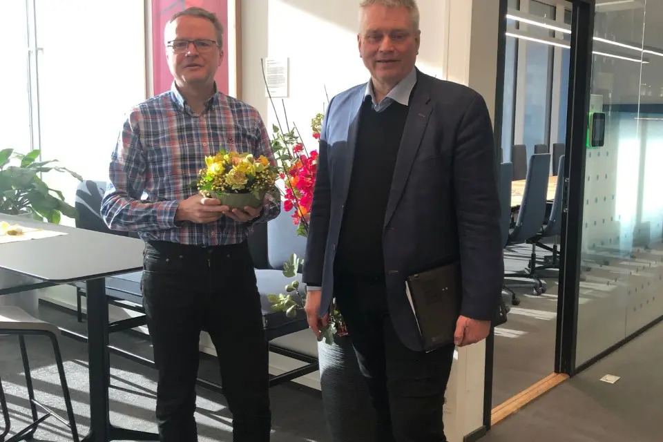 To menn står ved siden av hverandre