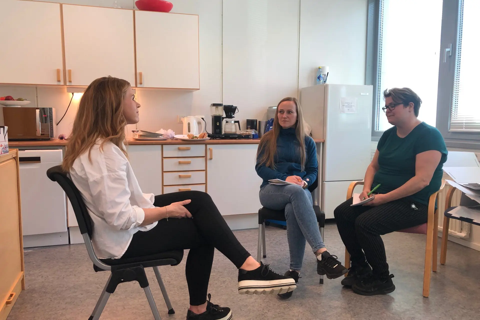 Tre damer sitter ie en halvsirkel