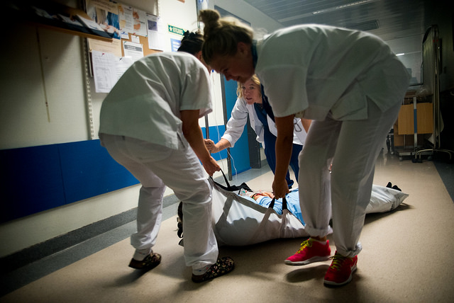 Tre hvitkledde personer evakuerer en 