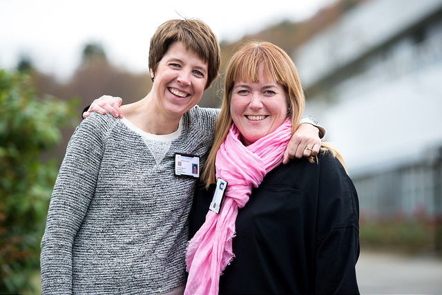 To kvinner smiler og holder rundt hverandre