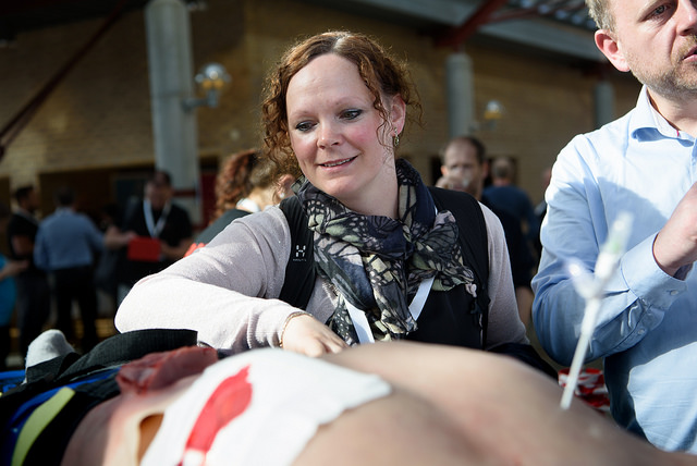 En kvinne står over en simuleringsdukke.