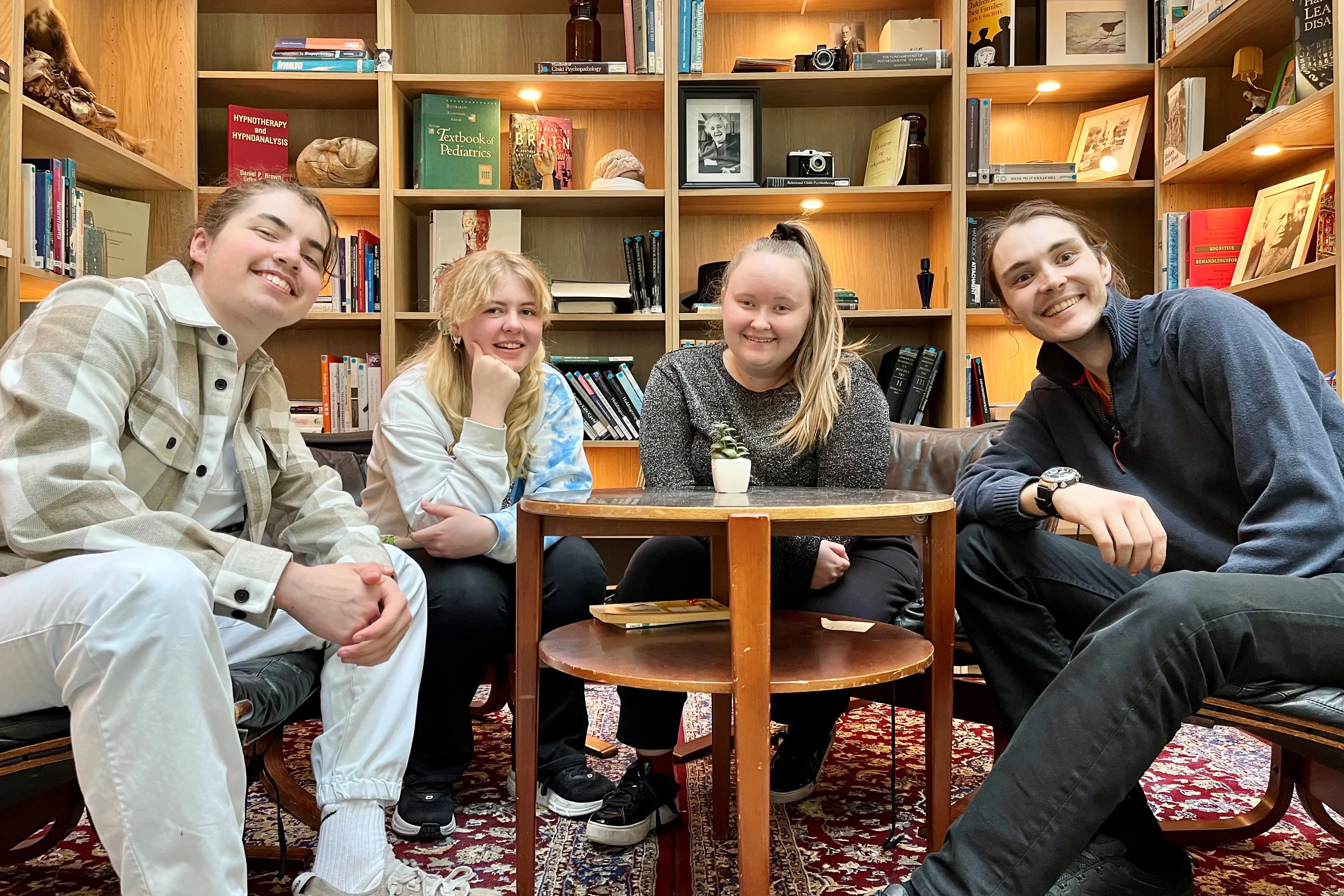 Fire ungdommer sitter rundt et bord.