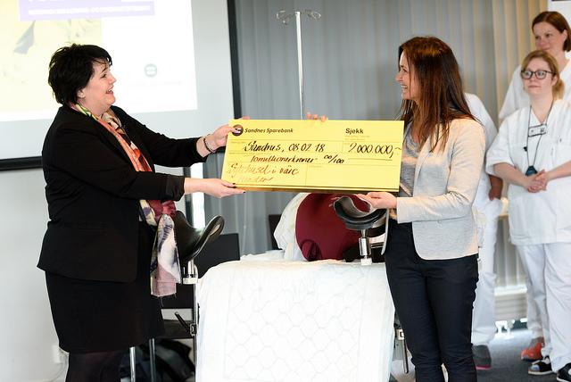 To kvinner holder i en sjekk lydende to millioner kroner.