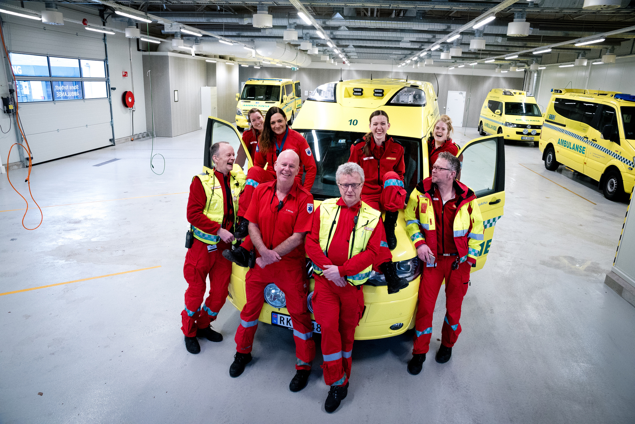 En gruppe mennesker i oransje jumpsuits i en garasje