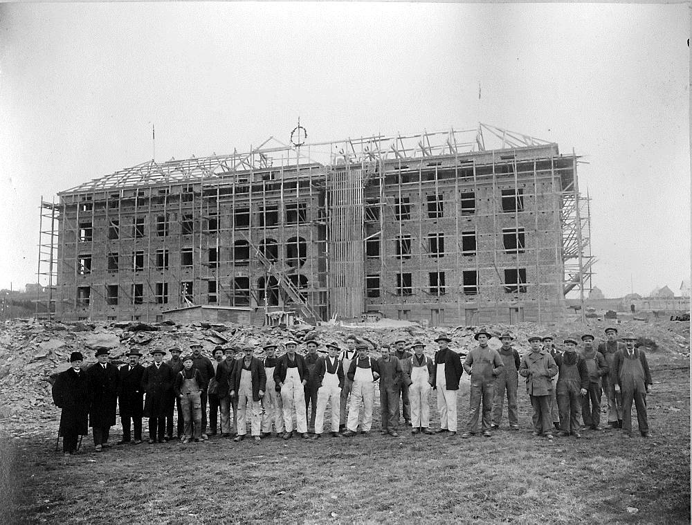 En gruppe mennesker som står foran en bygning